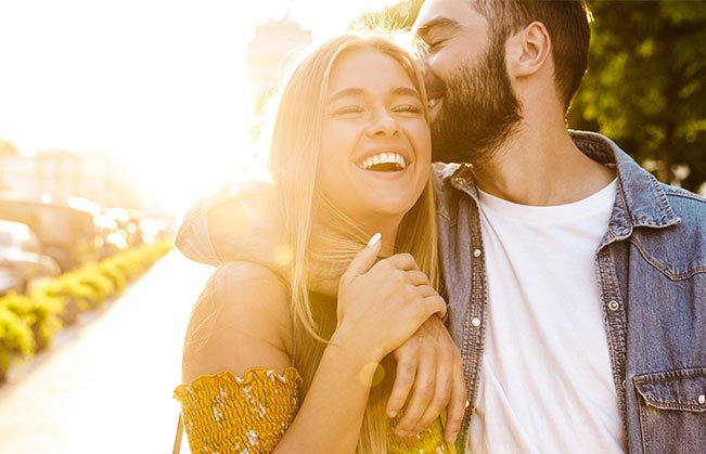 Man and woman with healthy smiles after dental crown restoration