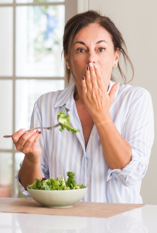 Person covering mouth before gum disease treatment